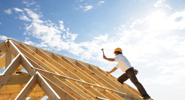 Construction worker building roof of home
