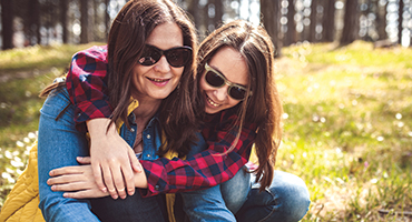 Mother and daughter hugging in a field