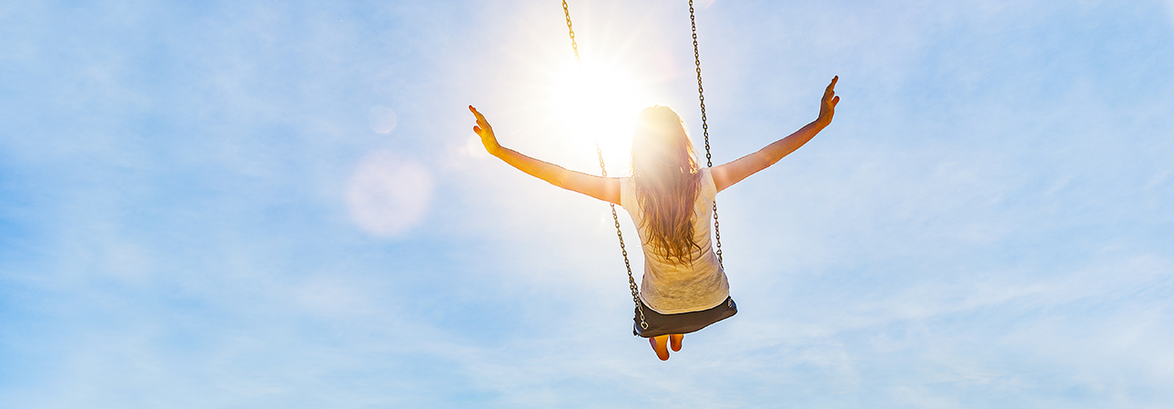 Woman on swing with outstretched arms