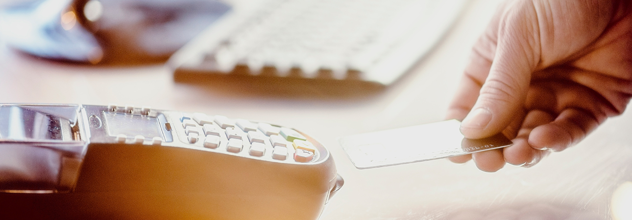 hand inserting debit card into payment terminal